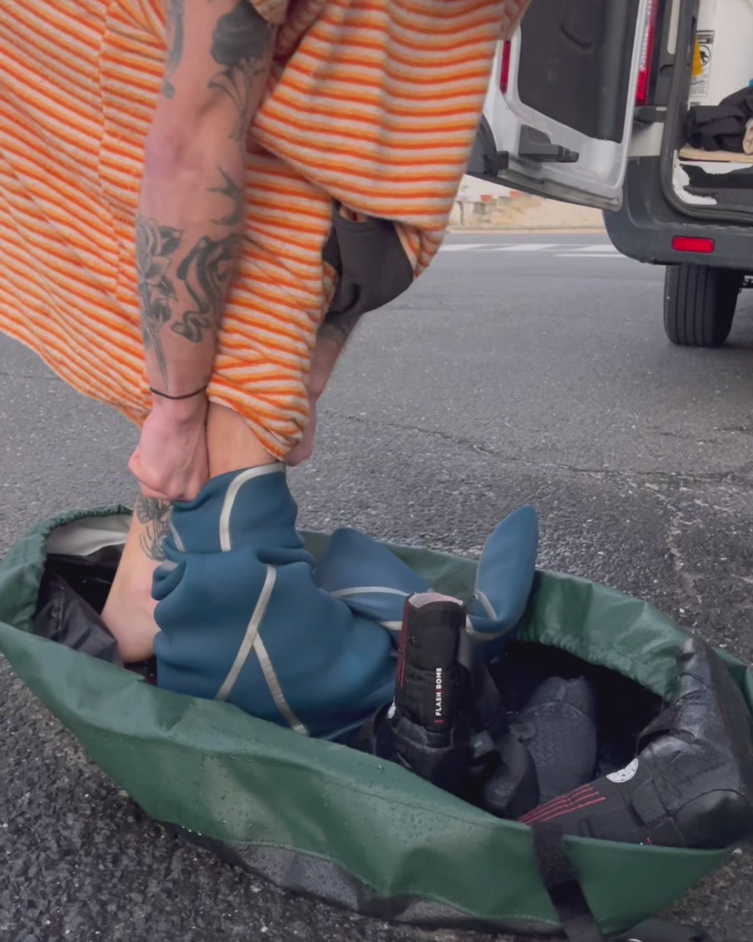 Surfer using the clamshell bag wetsuit changing bag and wetsuit mat